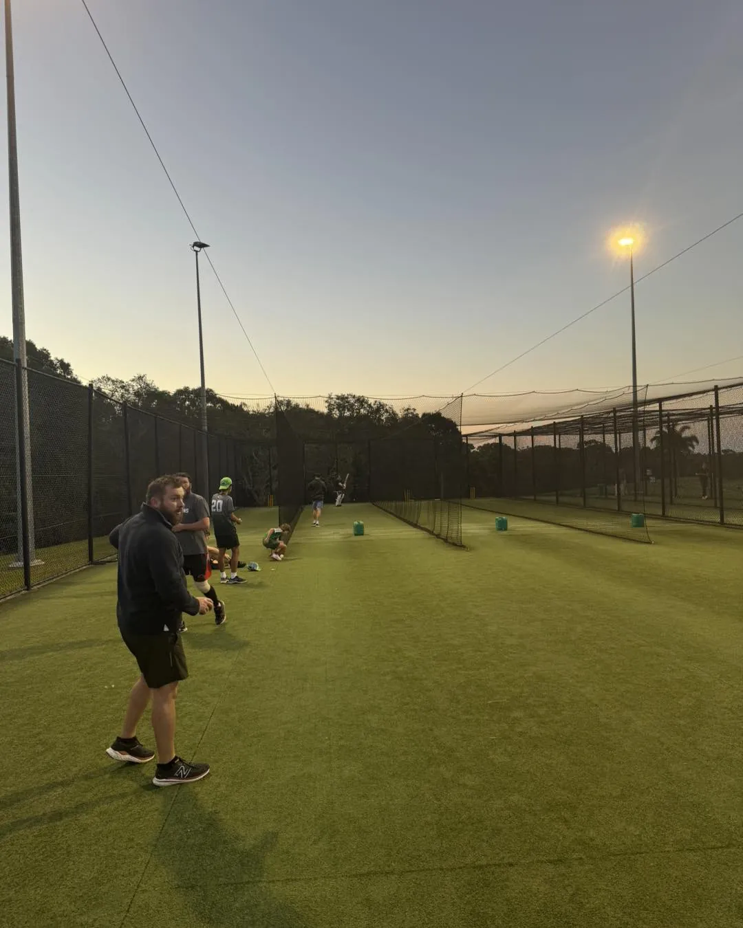 Muddies players training in the nets at sunset